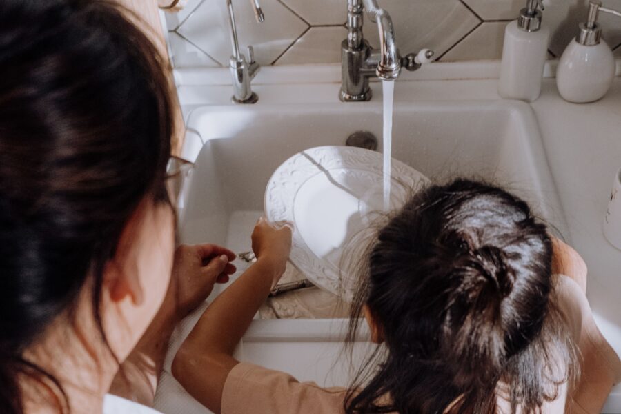 Parent guiding a child as they learn responsibility through everyday tasks